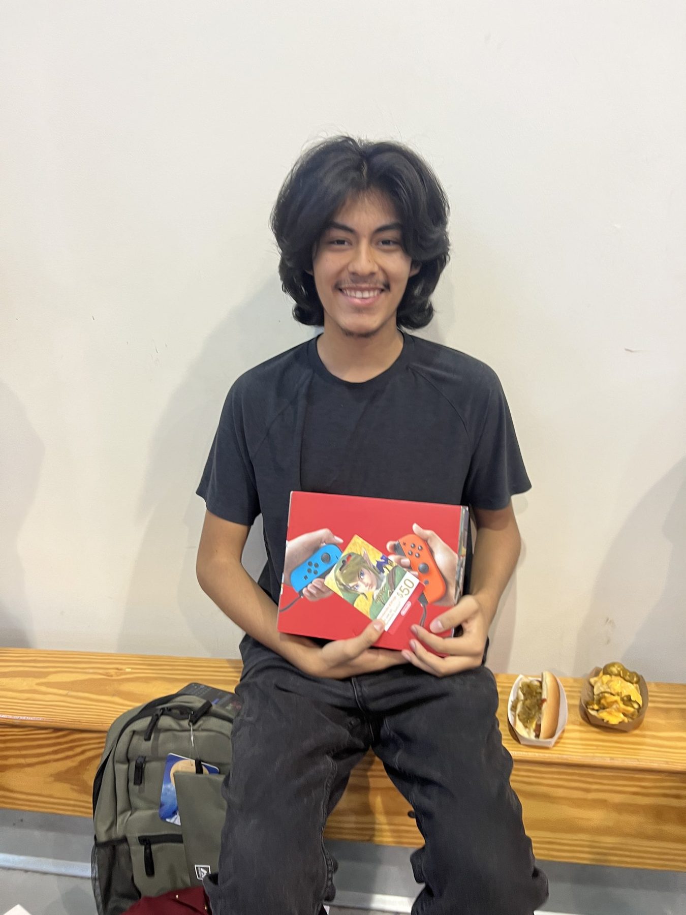 A student smiling with an award at the Department of Youth Development event