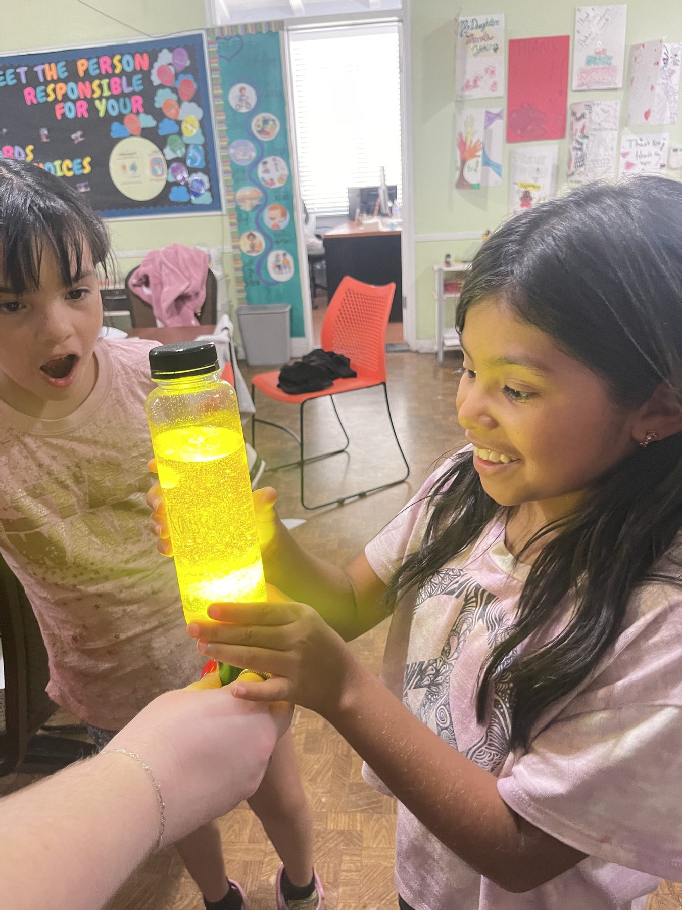 A summer camp student beaming over a glowing science experiment