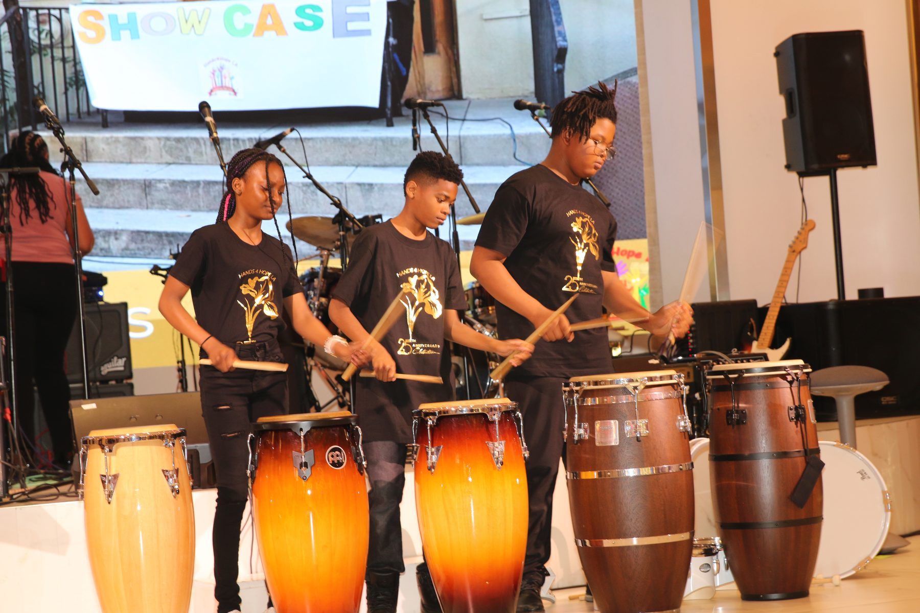 Mentors playing congas and timbales at the showcase